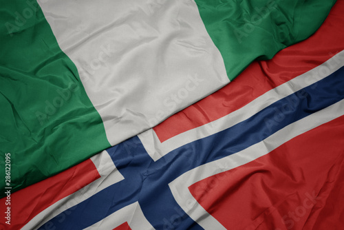 waving colorful flag of norway and national flag of nigeria.