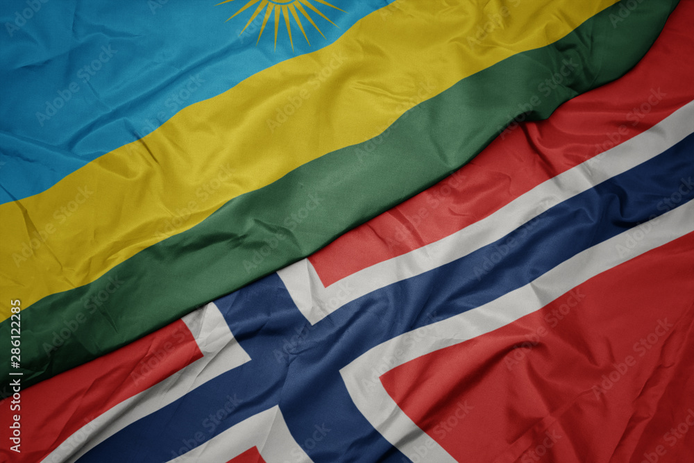 waving colorful flag of norway and national flag of rwanda.