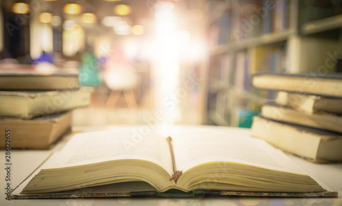 Canvas Print Open holy bible on table with blurred christian cross and light background