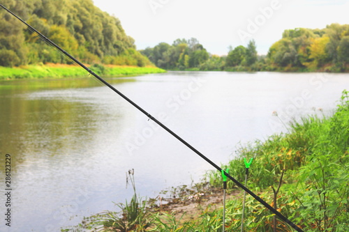 Fishing with feeder fishing rod on river, view from place of fisherman during fishing