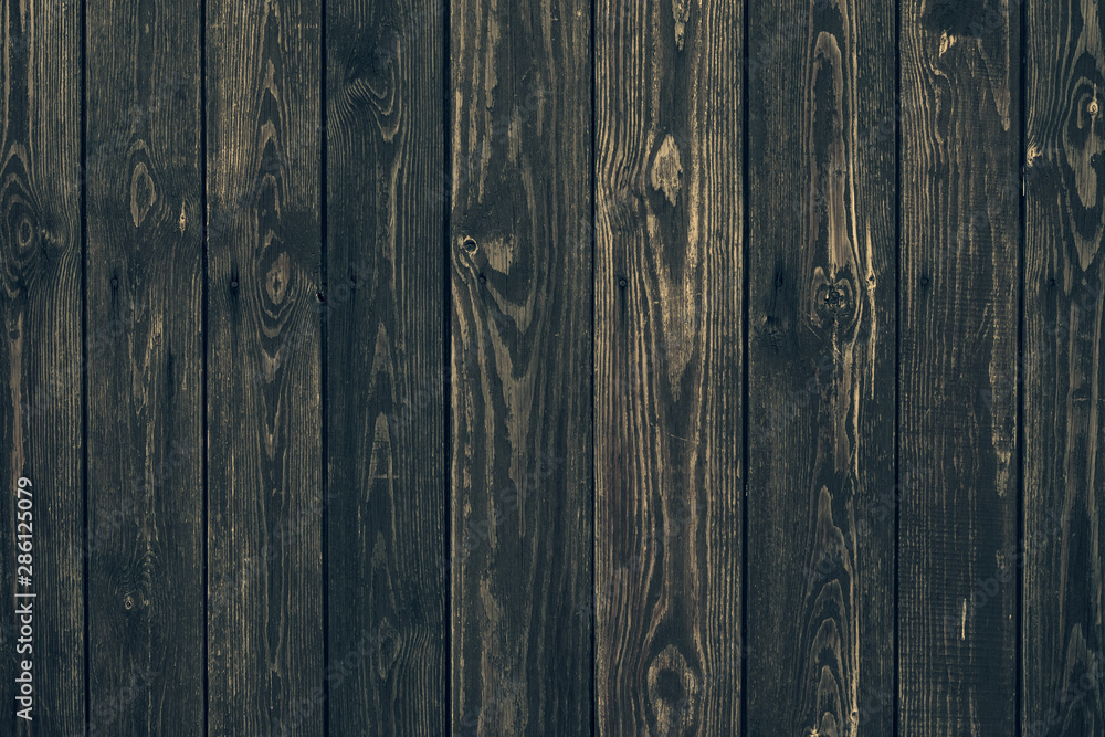 Naklejka premium Vintage black vertical wood planks. Brown wooden grunge timber boards. Dark wooden panel texture. Dirty fence, carpentry hardwood. Natural material, rough surface of oak table. Vintage weathered floor