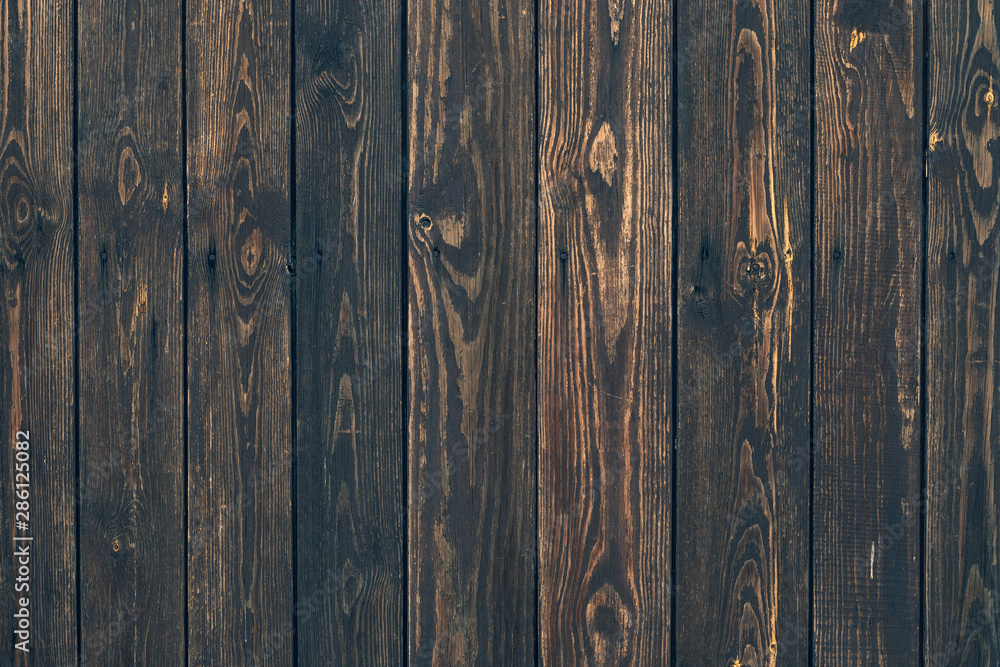Fototapeta premium Dark wood vertical planks. Wooden rustic pattern of timber floor. Dirty wall, brown pine texture. Abstract natural background.