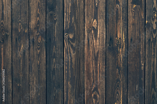 Dark wood vertical planks. Wooden rustic pattern of timber floor. Dirty wall, brown pine texture. Abstract natural background.