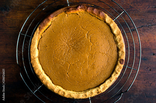 Overhead view of pumpkin pie on cooling rack photo