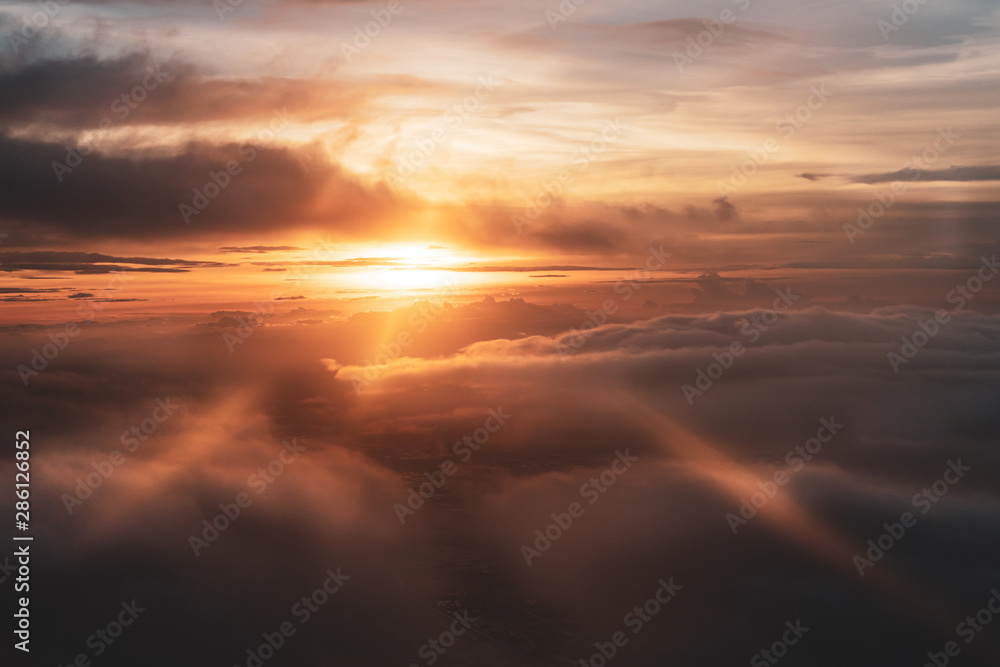 Beautiful sunset sky with light rays view from airplane
