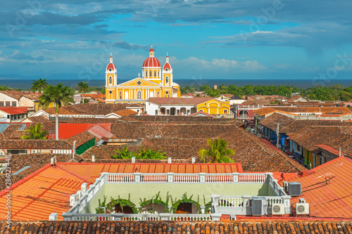 Fotografia Urban skyline of Granada city at sunset with its spanish colonial architecture, colorful cathedral and beautiful rooftops with the Nicaragua Lake in the background, Nicaragua, Central America
