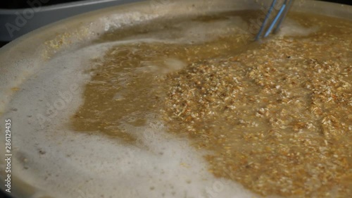 Brewing beer and Stirring malt mash in a home brewing process photo