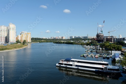 Boats and yachts at the pier of the yacht club Shore House in Myakininskaya floodplain on the banks of the Moscow river near " Crocus city"
