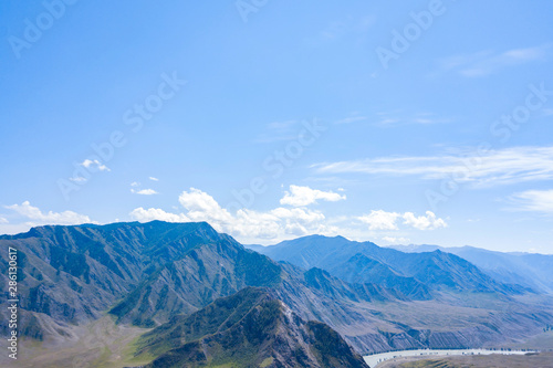 Aerial landscape with mountains and river under blue sky in summer