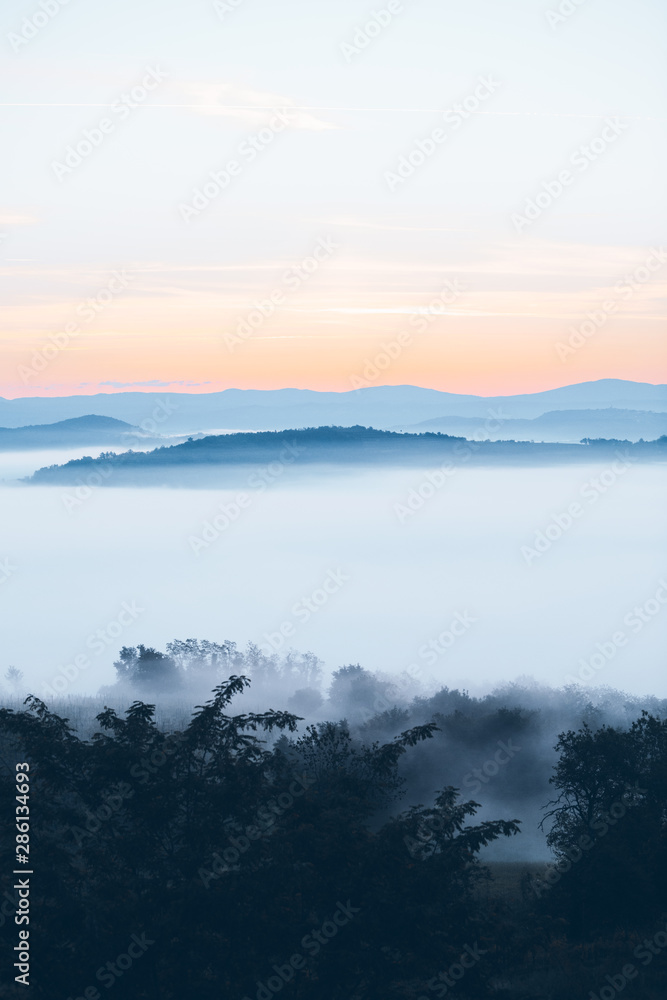 view of sunrise over the mountains mist and clouds under peaks view of sunrise over the mountains mist and clouds under peaks