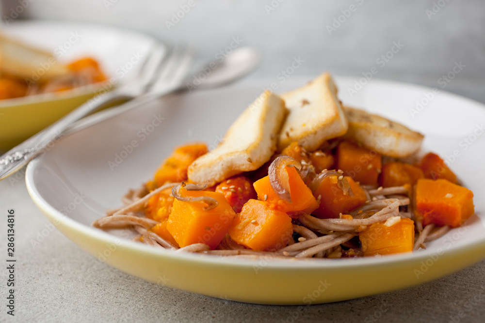 Close up of noodles with squash and tofu served on plate Close up of noodles with squash and tofu served on plate