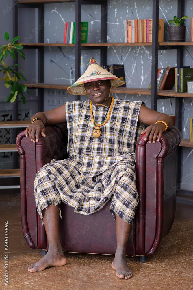 Happy Handsome african man in traditional clothes sitting on chair Happy Handsome african man in traditional clothes sitting on chair