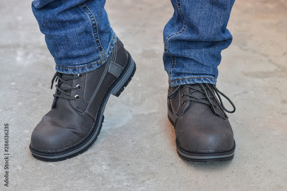 Young fashion man's legs in jeans and boots Young fashion man's legs in jeans and boots