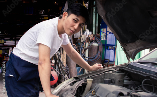 A man is fixing machine of car © Ann Rodchua