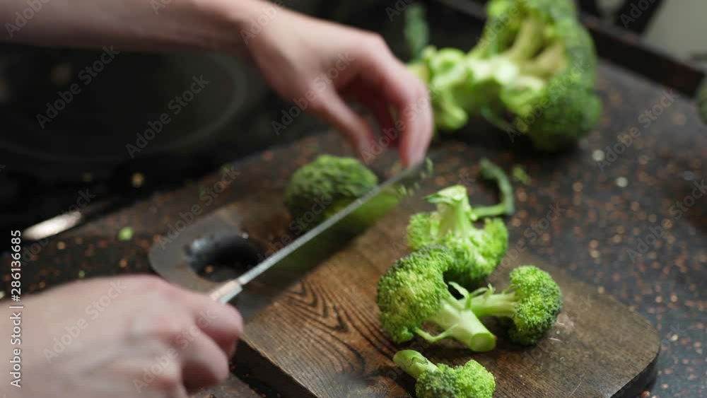 Female cook broccoli. cooking delicious fresh salad for healthy vegan lunch closeup