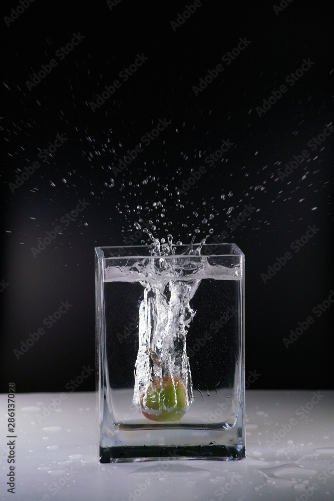 Pomme, plongeant dans un vase rempli d'eau Photos | Adobe Stock