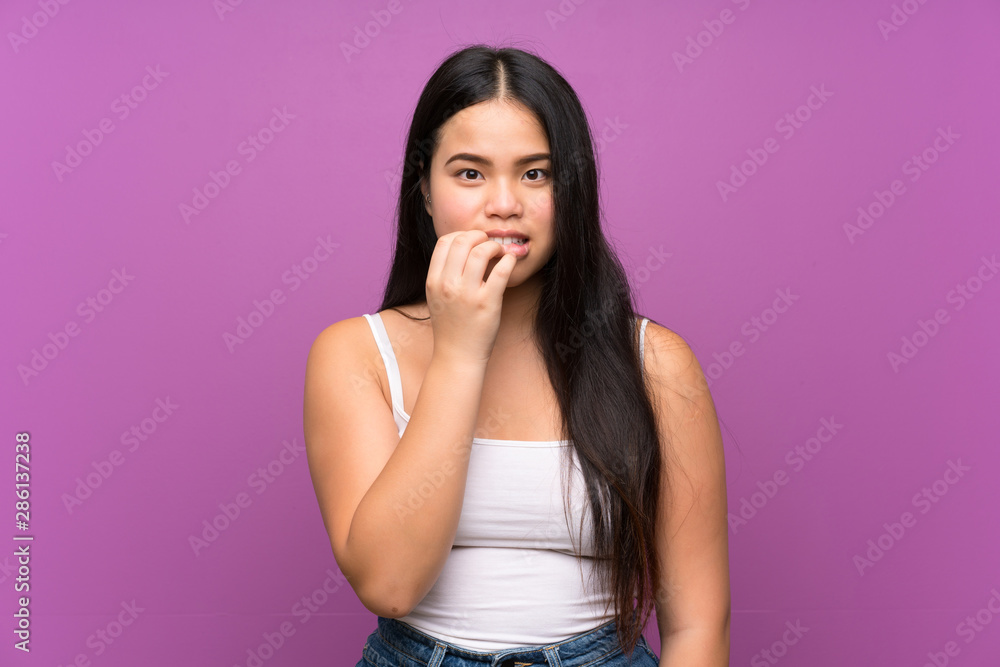 Young teenager Asian girl over isolated purple background nervous and scared Young teenager Asian girl over isolated purple background nervous and scared