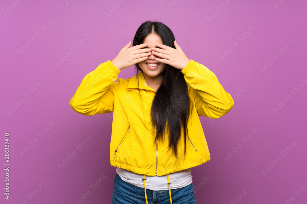 Young teenager Asian girl over isolated purple background covering eyes by hands Young teenager Asian girl over isolated purple background covering eyes by hands