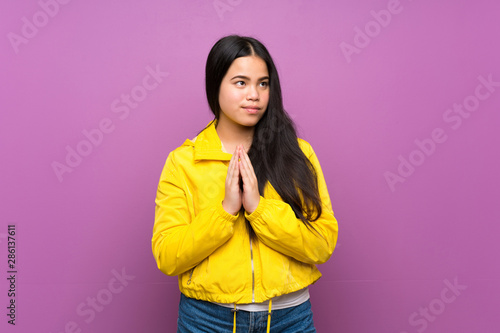 Young teenager Asian girl over isolated purple background scheming something