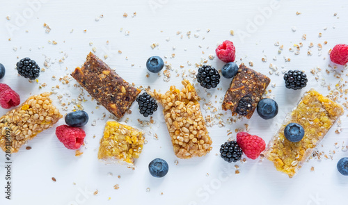 Pattern with cereal bars and blueberries, blackberries and raspberries with oatmeal. Healthy snacks and breakfasts