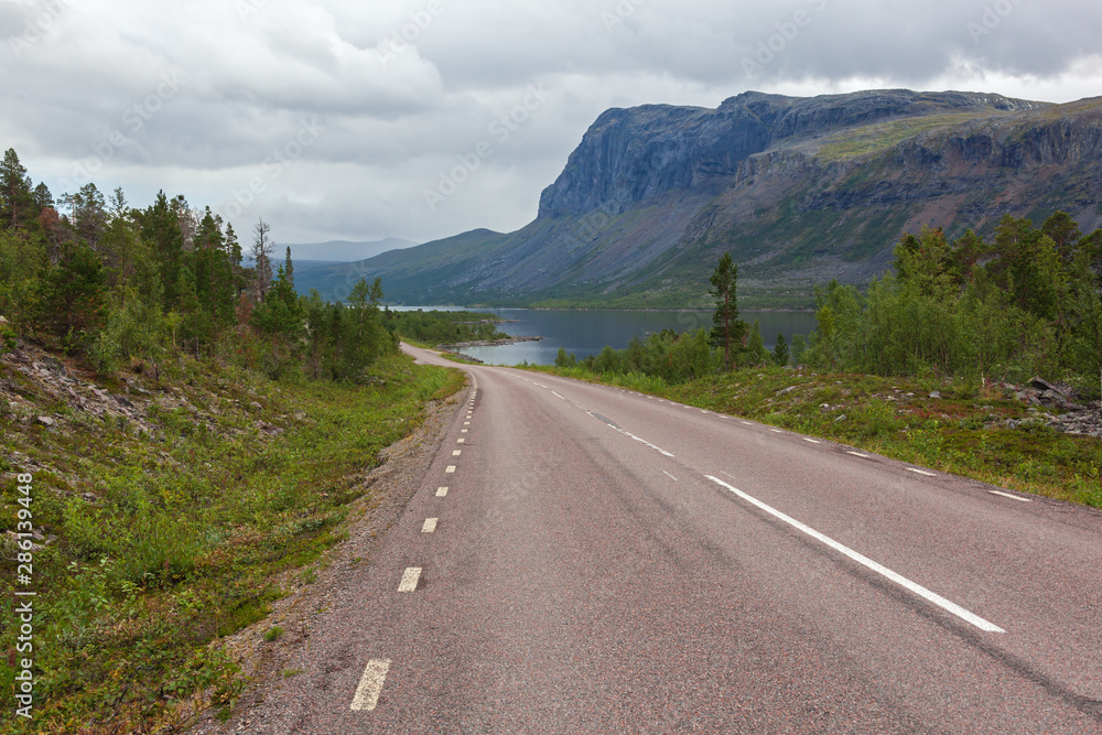 Road across Swedish Lapland with picturesque view of the mountains of Sarek national park