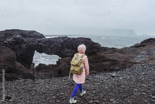 Icelandic black sand beach. Amazing lanscape nature in Iceland. Woman travelling with travel bag