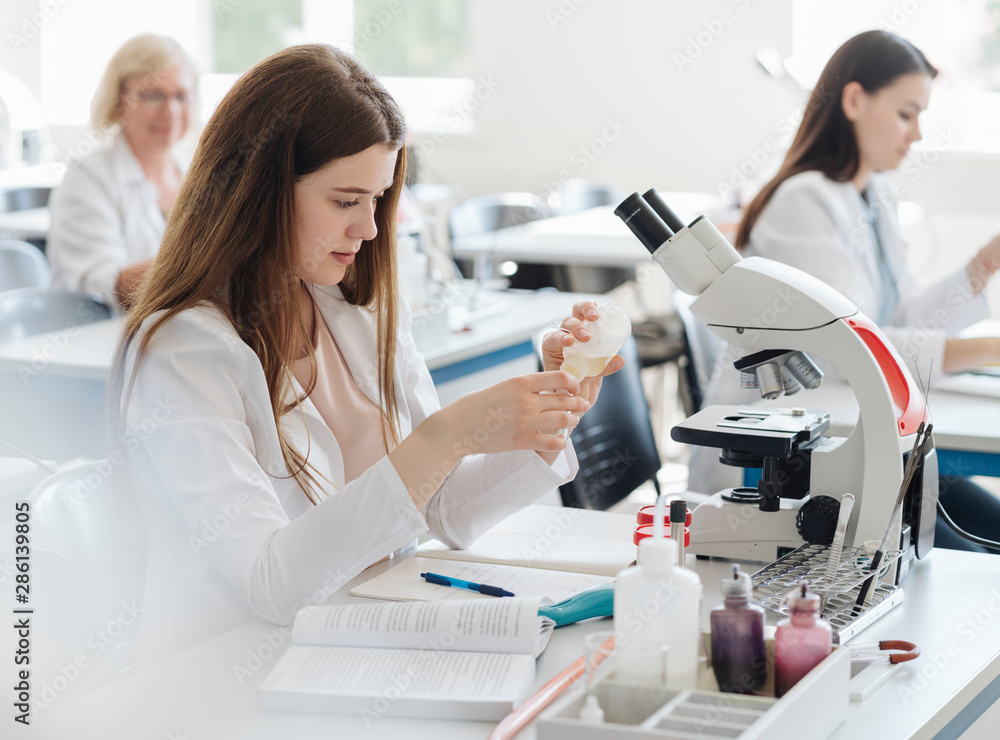 Researchers in white coats working in lab Researchers in white coats working in lab