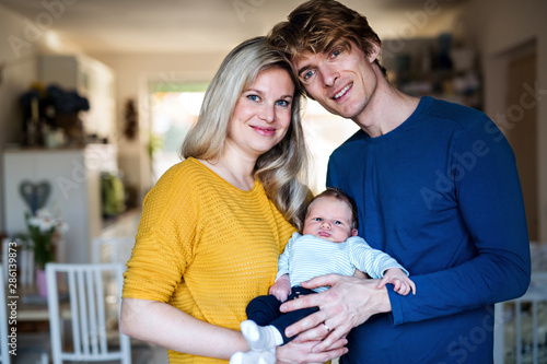 Beautiful young parents with a newborn baby at home.