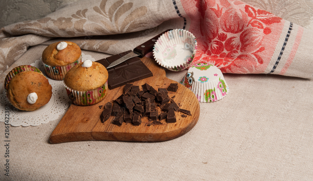 Homemade baking. Vanilla muffins with pieces of chocolate, dark chocolate on a linen napkin. Homemade baking. Vanilla muffins with pieces of chocolate, dark chocolate on a linen napkin.
