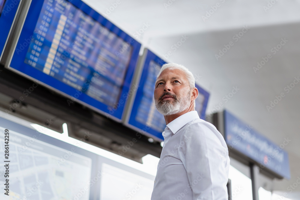 Mature businessman at departures board Mature businessman at departures board