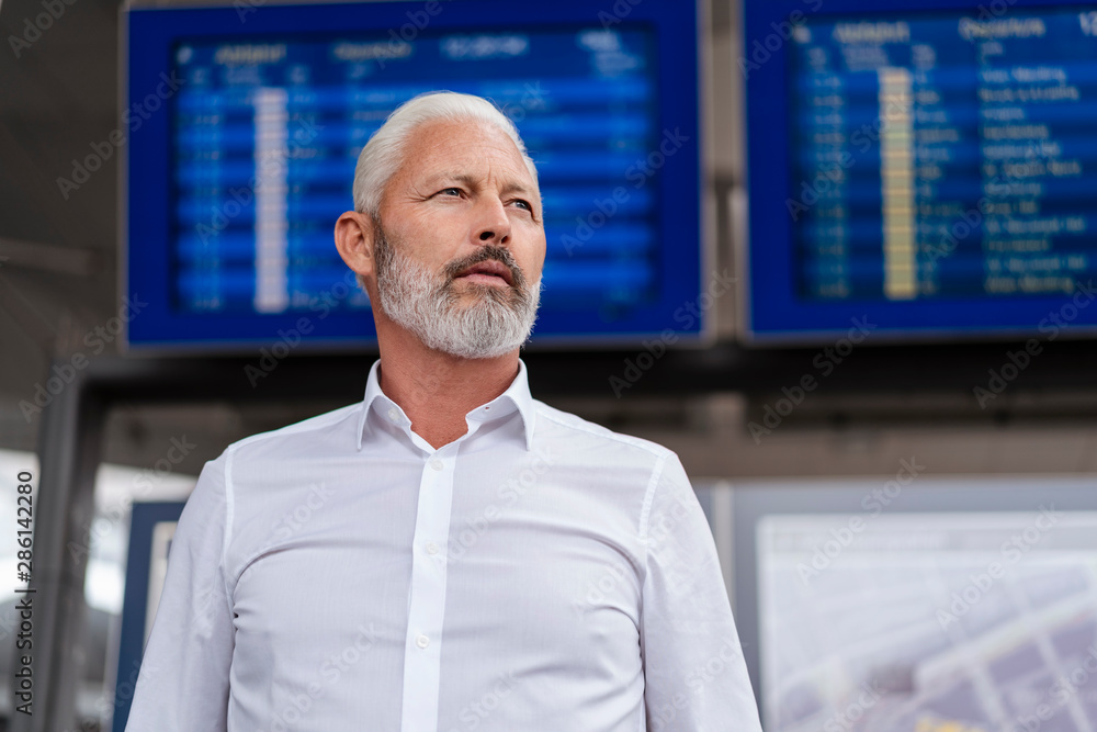 Mature businessman at departures board Mature businessman at departures board