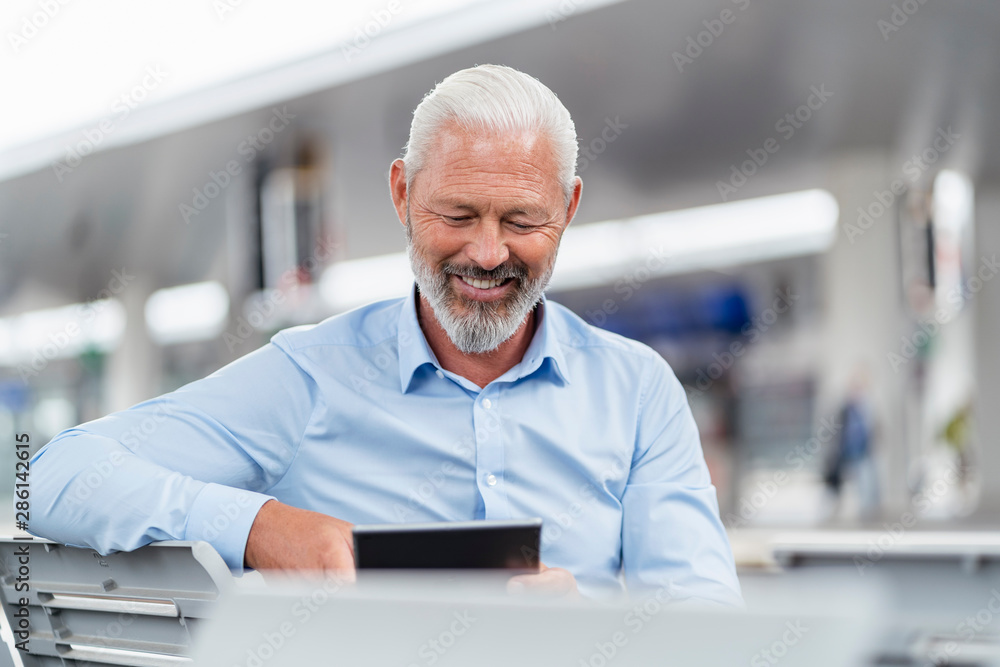 Mature businessman on a journey using tablet Mature businessman on a journey using tablet