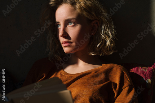 Portrait of pensive young woman with book