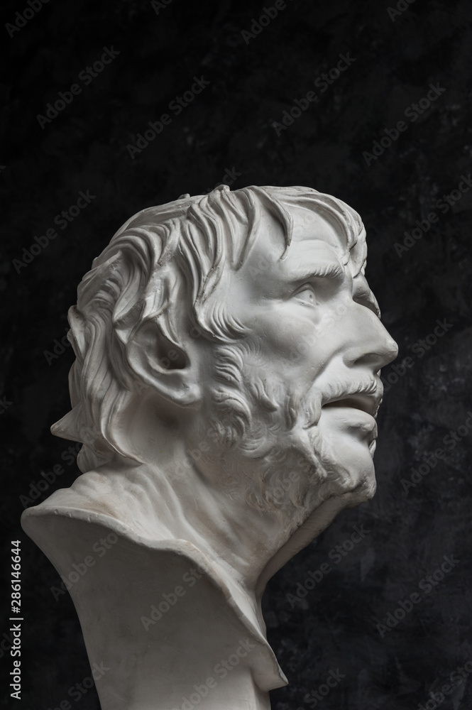 Gypsum copy of ancient statue Seneca head on dark textured background. Plaster sculpture man face. Gypsum copy of ancient statue Seneca head on dark textured background. Plaster sculpture man face.