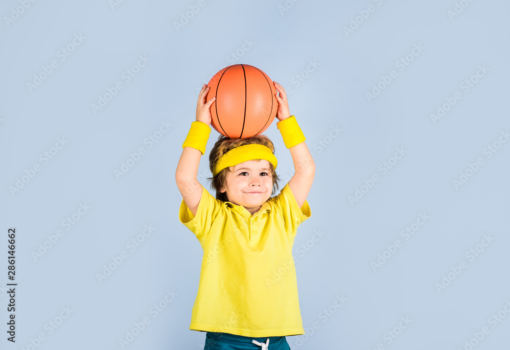 Fototapeta premium Basketball training. Child boy in sportswear throws ball. Active sports lifestyle. Sport game. Kid activities. Little basketballer. Sports equipment. Cute boy playing basketball. Enjoy sport game.