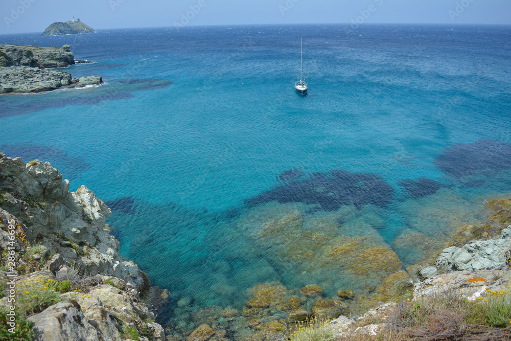 Sailing boat near the coast of Sentier des douaniers, Cap Corse. Corsica island, France