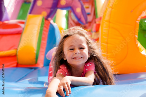 Foto A cheerful child plays in an inflatable castle