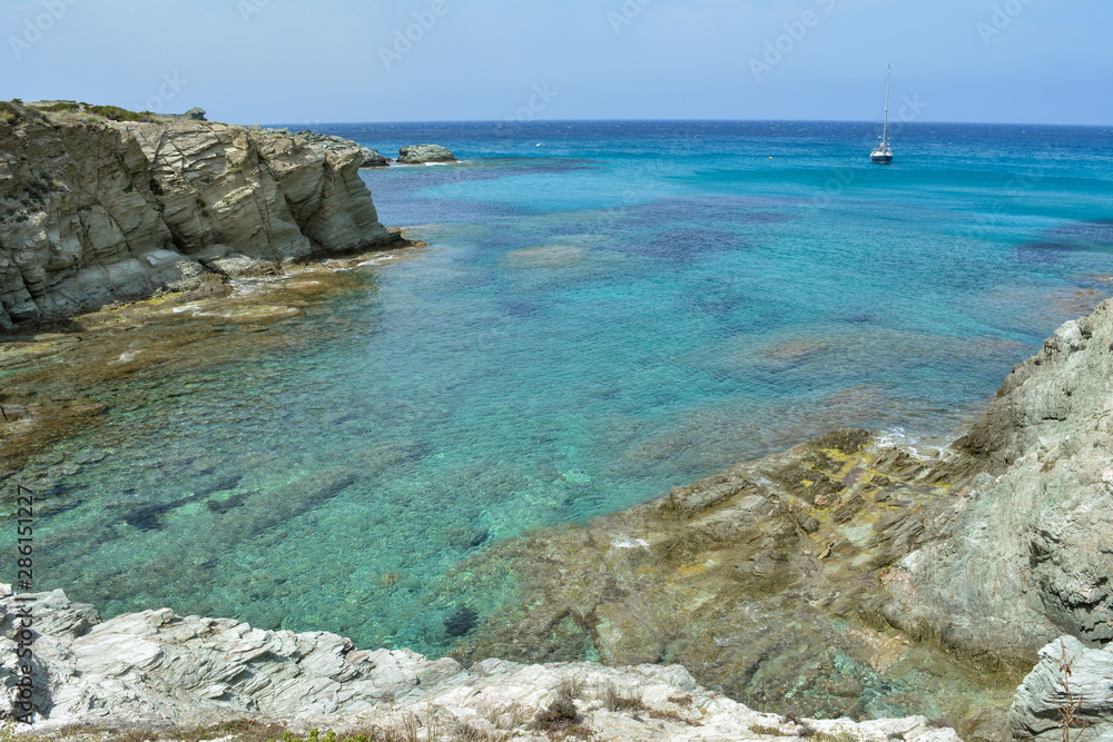 Sailing boat near the coast of Sentier des douaniers, Cap Corse. Corsica island, France