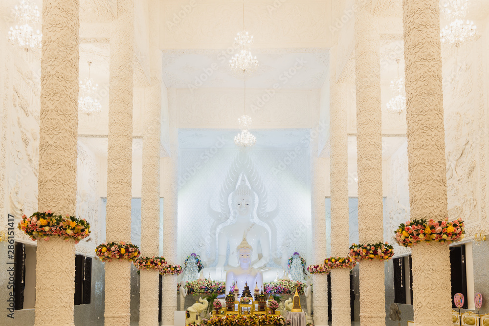 Beautiful White Buddha statue in a white hall at Wat Huay Pla Kung, the beautiful and famous Thai-Chinese temple in Chiang Rai Province, Thailand. - obrazy, fototapety, plakaty 