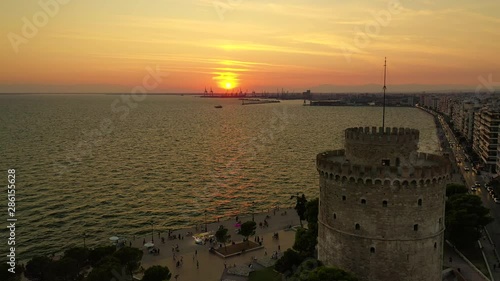 Aerial drone view video of iconic historic landmark - old byzantine White Tower of Thessaloniki or Salonica at sunset with golden colours, North Greece photo