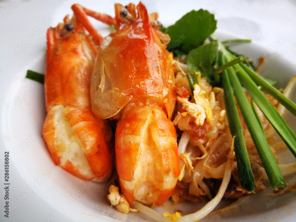 Asian rice noodles, Thailand's national dishes with big shrimps and vegetables close-up on the table, Stir-fried noodles with egg. Thai call Asian rice noodles, Thailand's national dishes with big shrimps and vegetables close-up on the table, Stir-fried noodles with egg. Thai call