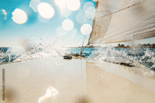 Water splashes on the deck of a small sailing boat