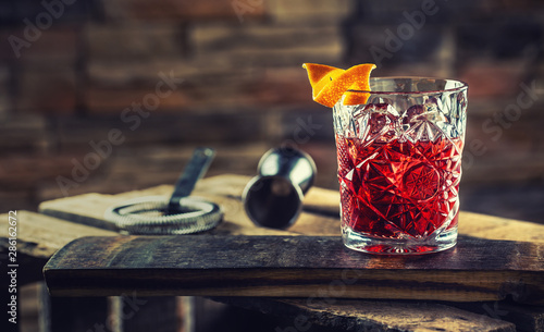 Cocktail Negroni on a old  wooden board. Drink with gin, campari martini rosso and orange