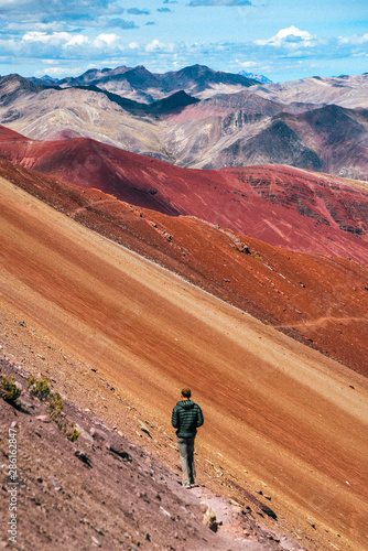 Hiker on Red Valley section of Rainbow Mountain hike in the Peruvian Andes near Cusco, Peru