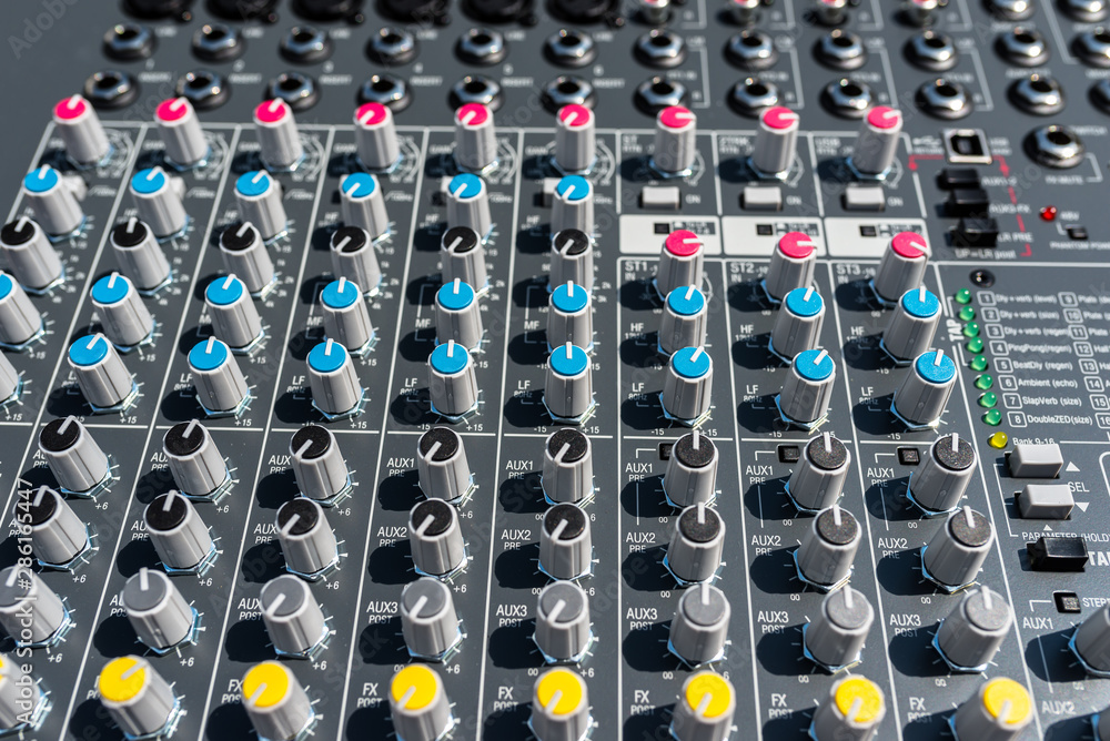 Fototapeta premium Close up photo of a professional sound mixer with many adjustments, knob switches and buttons of audio mixer control panel.