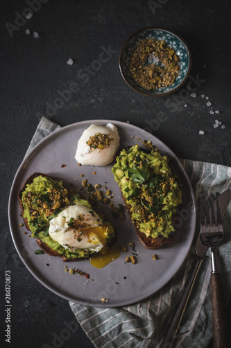 Poached egg on top of the sourdough toast with smashed avocado and dukkah spice