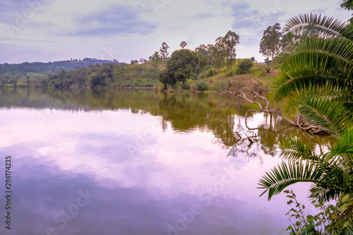 Sunrise view of Lake Nyabikere, with trees growing and the reflections on the water, Rweteera, Fort Portal, Uganda, Africa photo