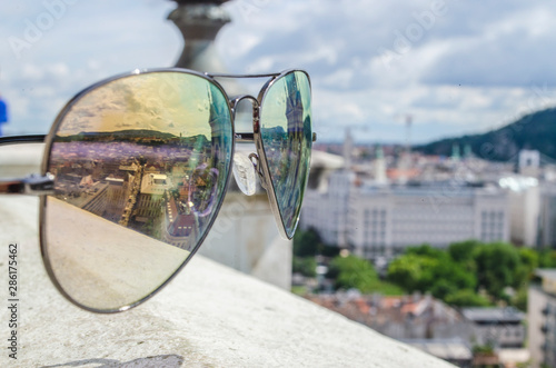 Surface Reflection of city from a top historic elevated landmark through the sunglass of a cloudy day photo