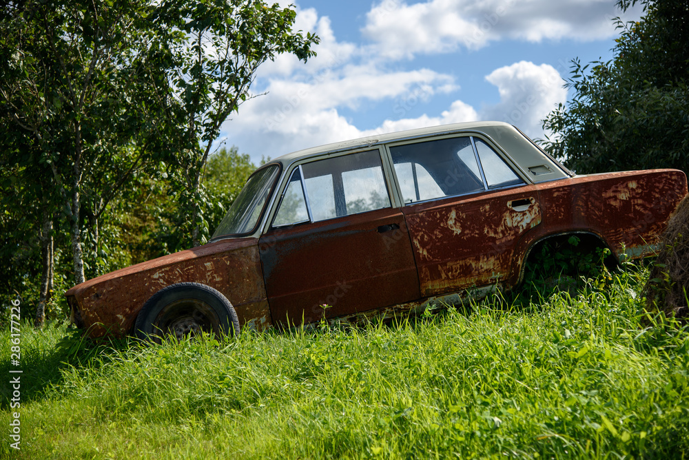 Old rusty and destroyed car. An old rusty and destroyed car abandoned in the nature Old rusty and destroyed car. An old rusty and destroyed car abandoned in the nature