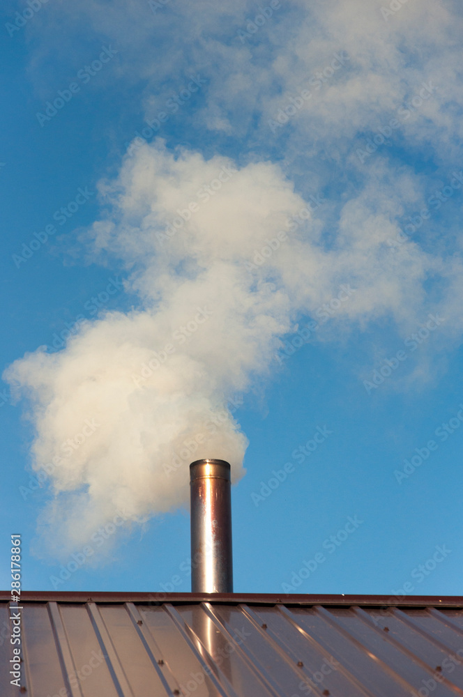 Smoke coming out the chimney against sky Smoke coming out the chimney against sky
